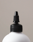 Gif showing the Alcôve Hair Violet Conditioner coming out of the nozzle of the bottle
