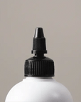 Gif showing the Alcove Volumizing Conditioner coming out of the nozzle of the white bottle