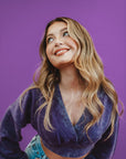 Woman wearing a purple top against a purple background