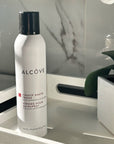 Bottle of Alcove Hair Strong Hold Hairspray in a bathroom