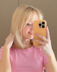 A blonde girl taking a selfie after using the Violet Shampoo - Alcôve Hair
