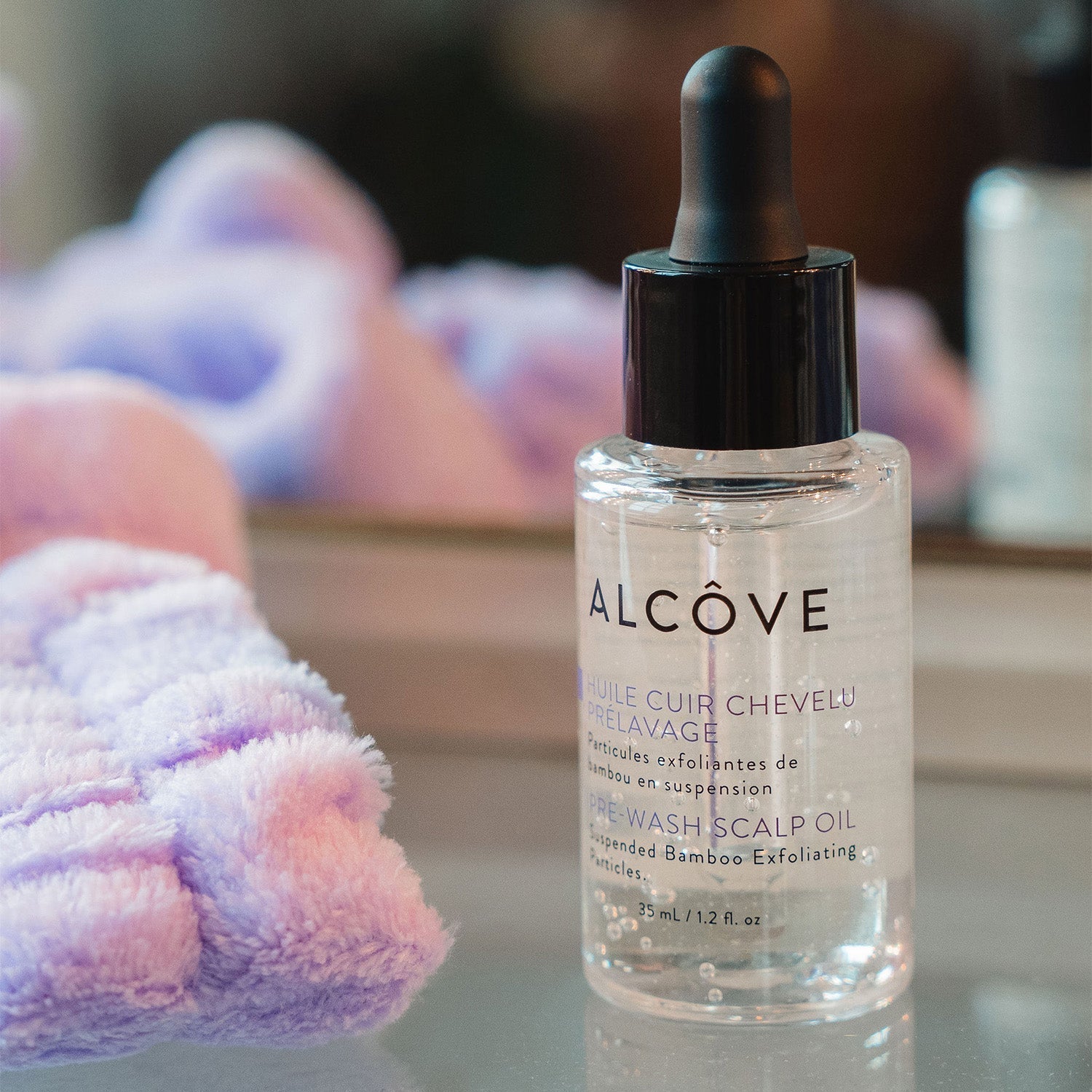 Image showing a hand using the pipe of the Alcôve Pre-Wash Scalp Oil