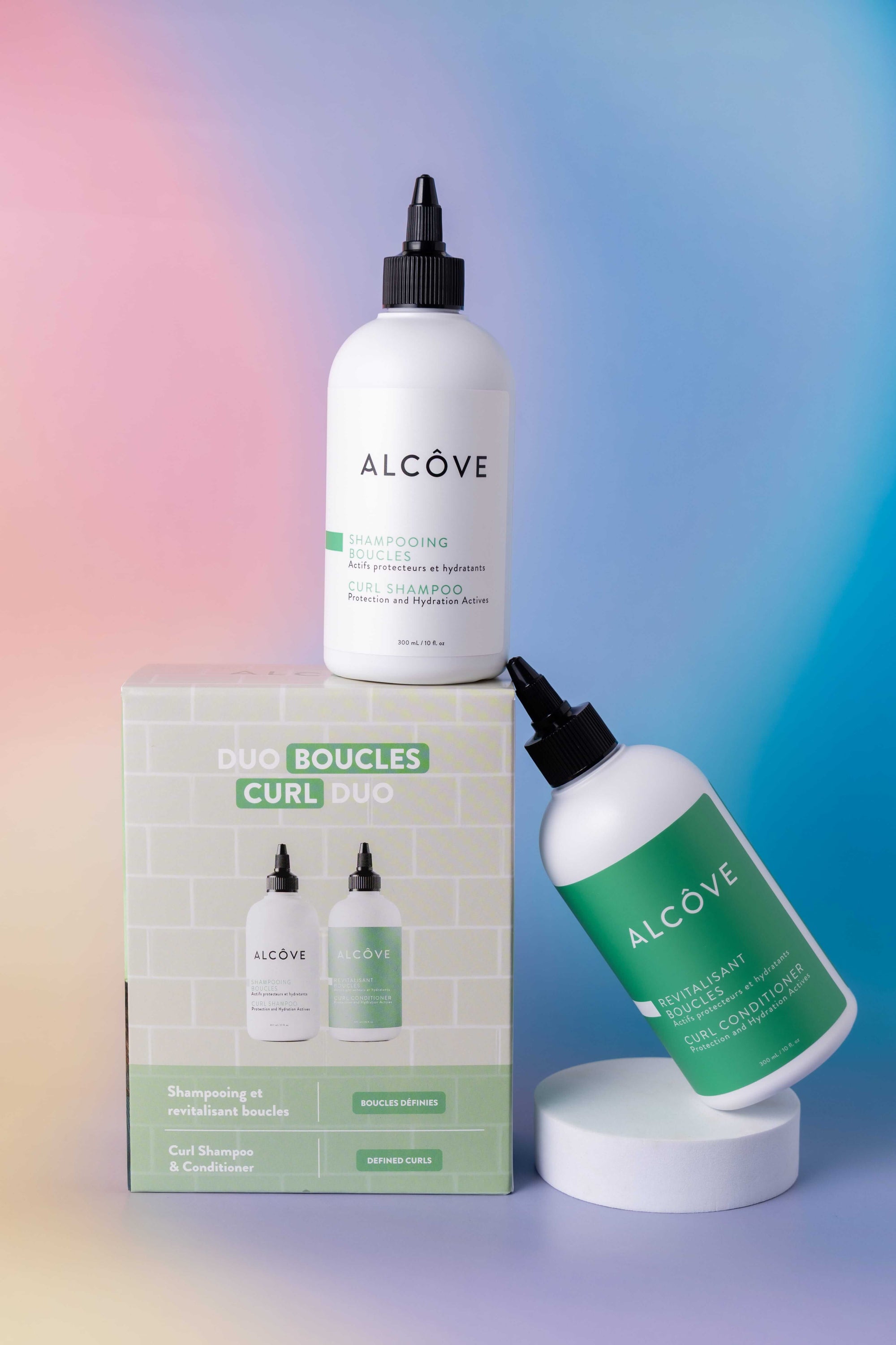 Alcove hair care products including bottles and a box on a gradient background