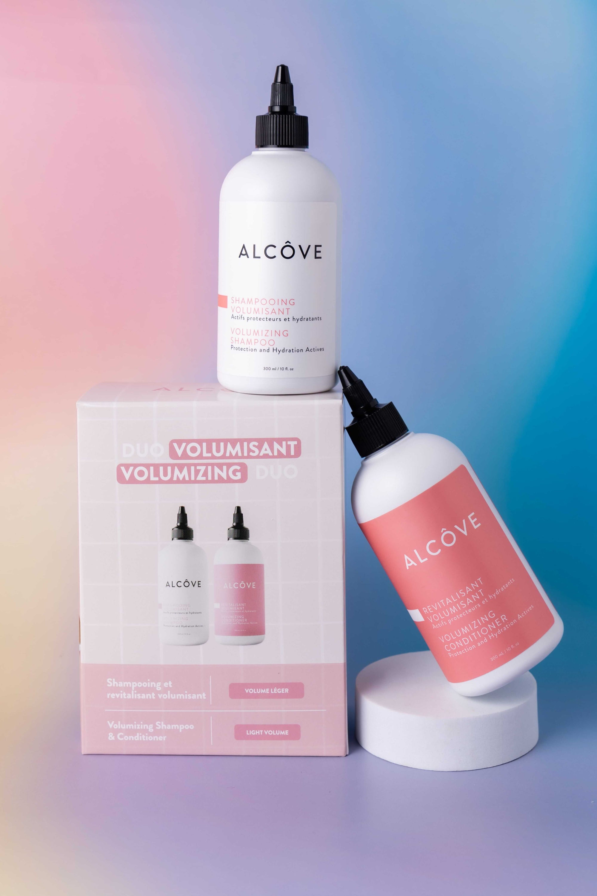 Alcove volumizing hair product with bottles and packaging on a gradient background