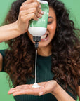 Person showing how to use the Alcôve Hair Curl Conditioner in the palm of her hand