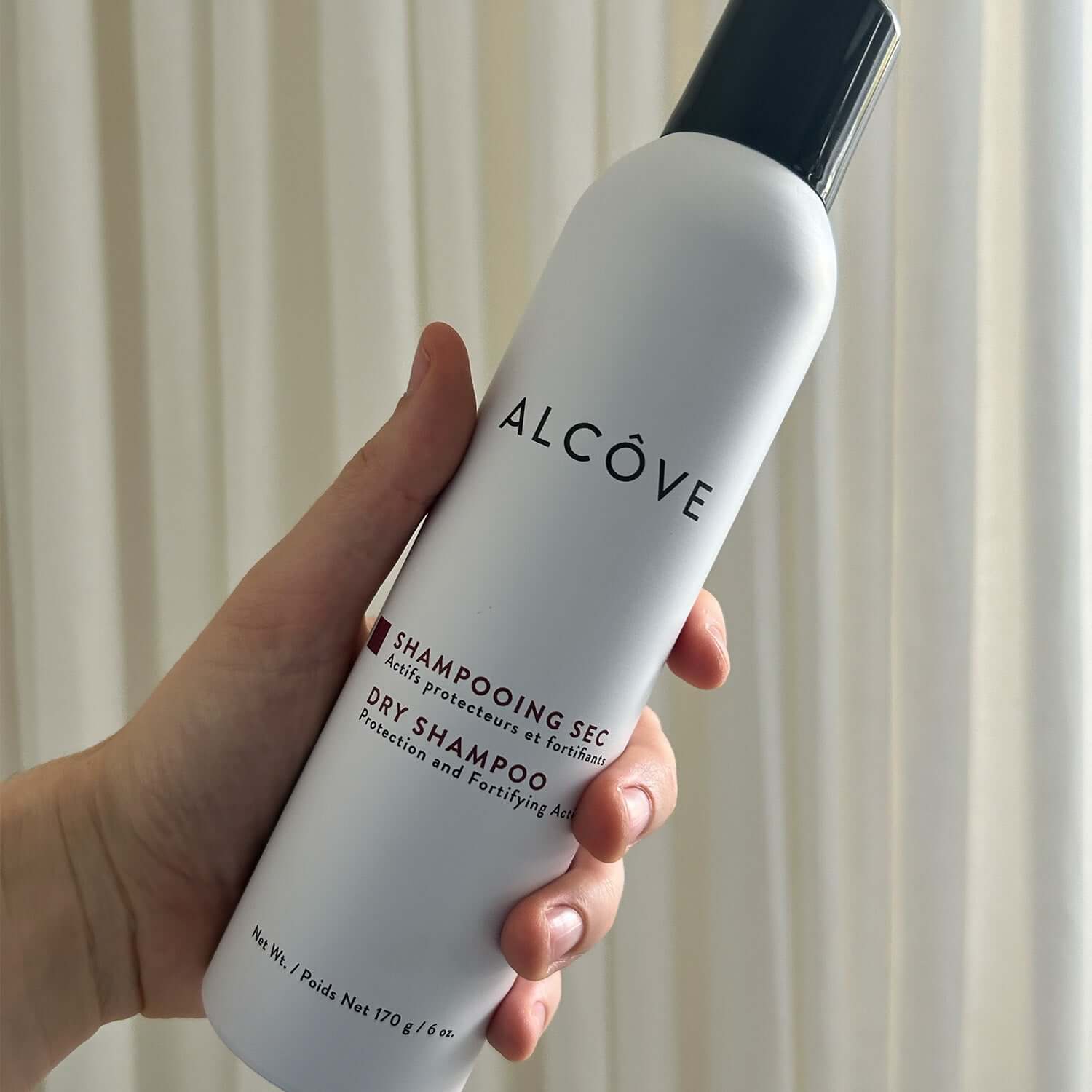 A picture of a hand showing the Alcove Hair Dry Shampoo - 170g - 6oz