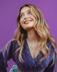 Woman wearing a purple top against a purple background