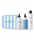 Set of Alcove hair care products including bottles and a striped pouch on a white background