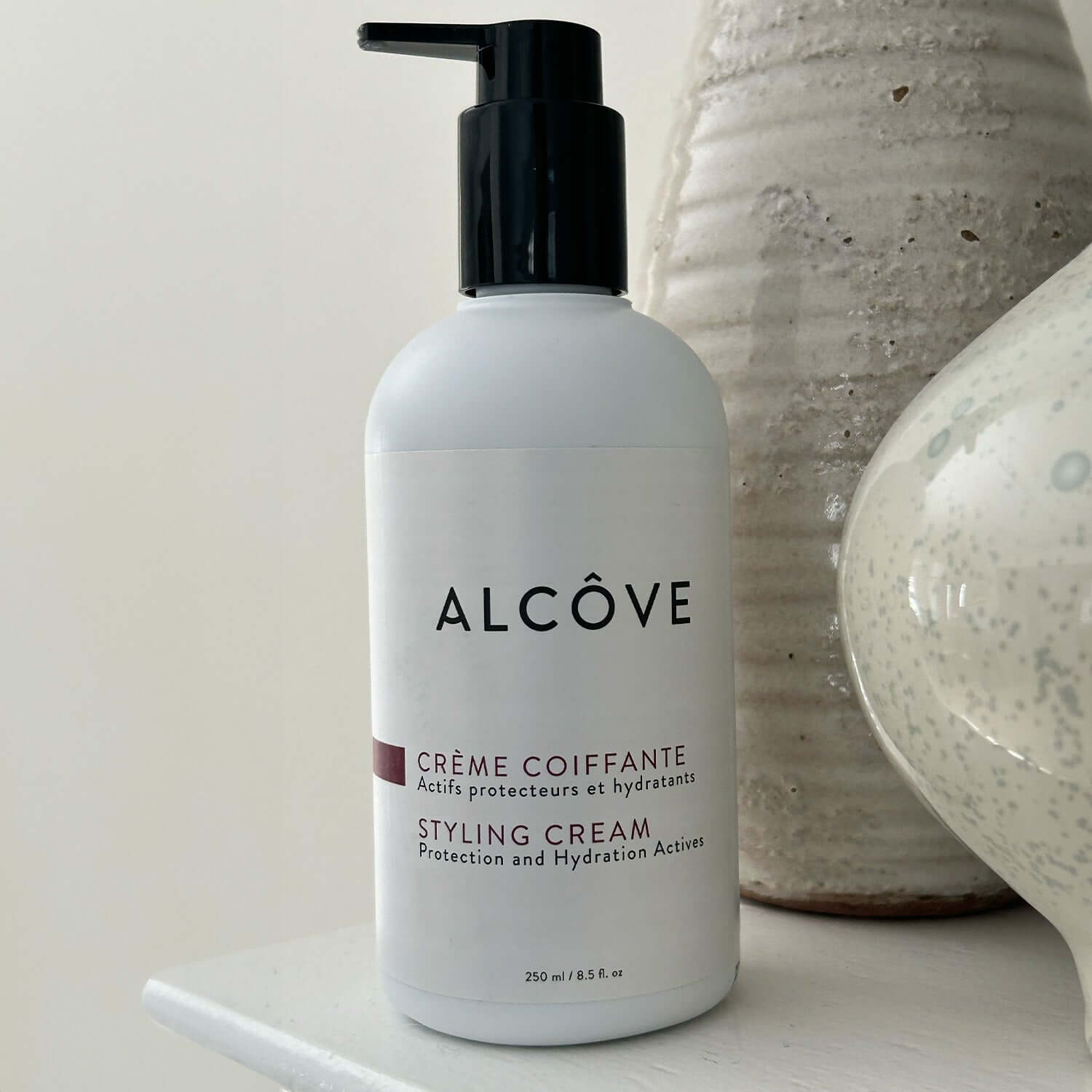 Picture of a Bottle of Alcove Hair Styling Cream 250 ml with a bathroom background