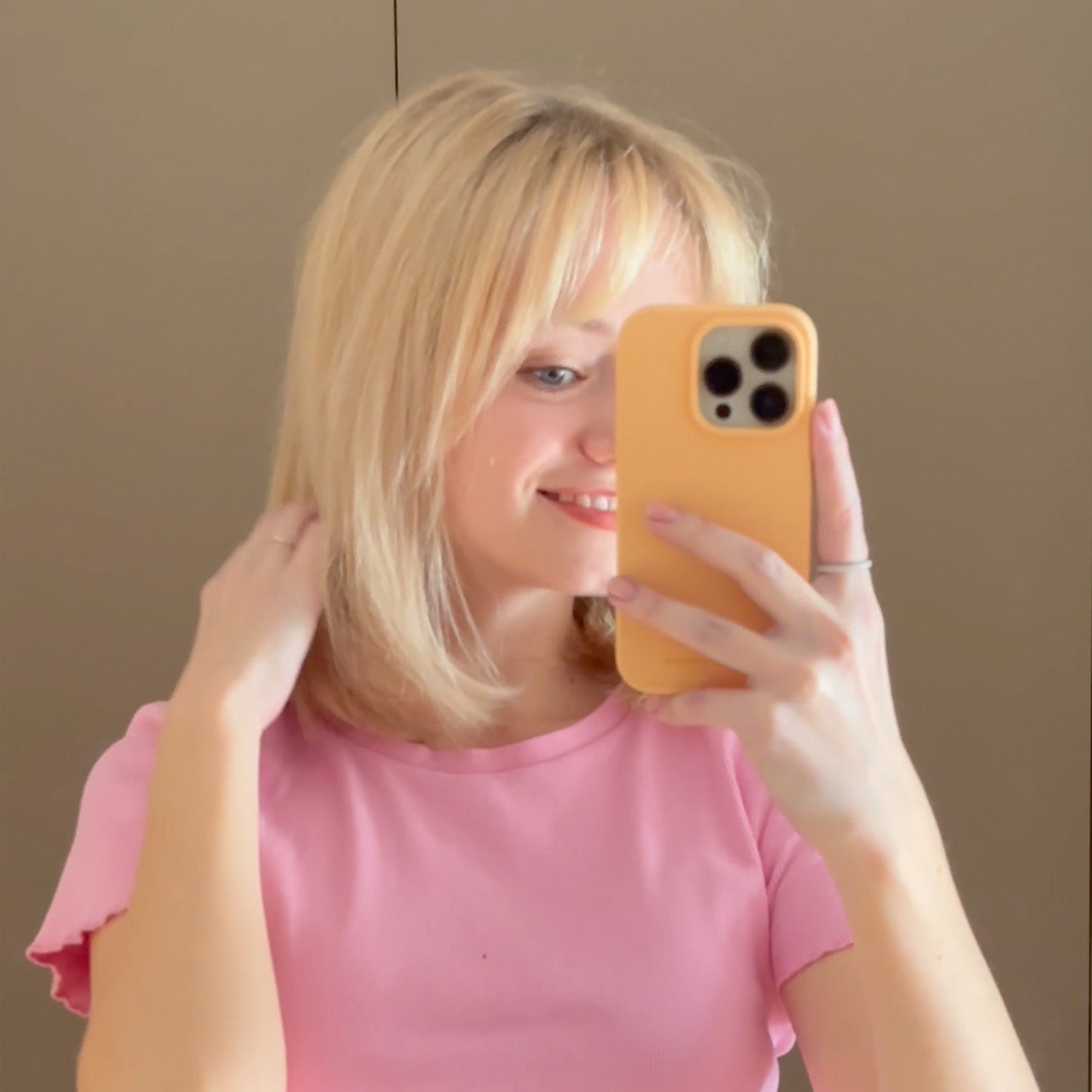A blonde girl taking a selfie after using the Violet Shampoo - Alcôve Hair